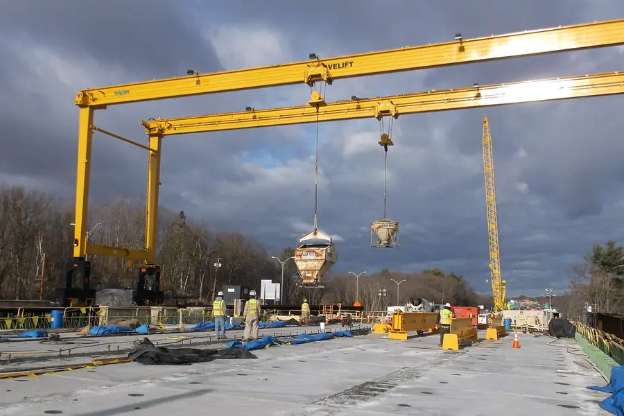 Gantry crane lowering a concrete kibble over a finished slab