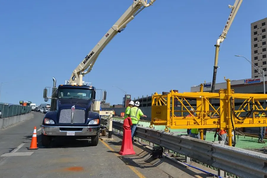 Concrete pump boom over a slab at the start of a pour